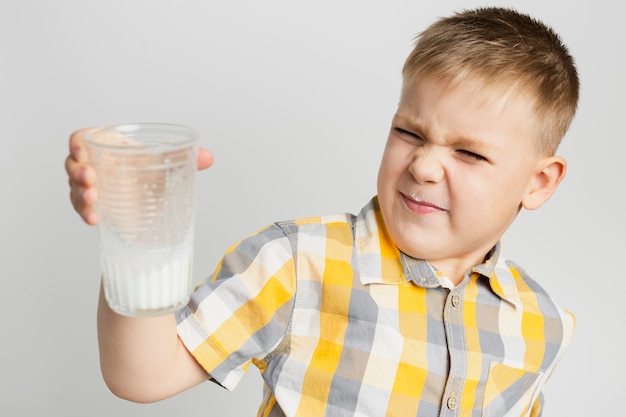 Jeune garçon idiot tenant un verre de lait