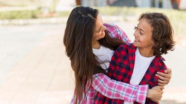 Jeune garçon et mère embrassés à l'extérieur