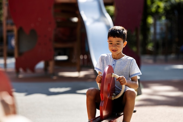 Jeune garçon s'amusant dans l'aire de jeux