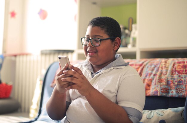 Un jeune garçon avec un smartphone à la maison