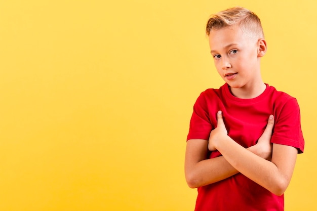 Photo gratuite jeune garçon tenant avec les bras croisés