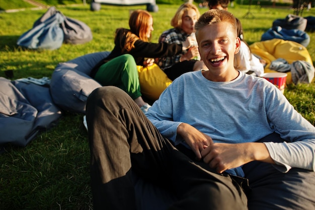 Photo gratuite jeune groupe multiethnique de personnes regardant un film au pouf dans un cinéma en plein air