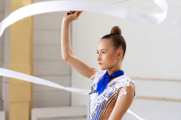 Photo gratuite jeune gymnaste au gymnase pratiquant avec ruban athlétique