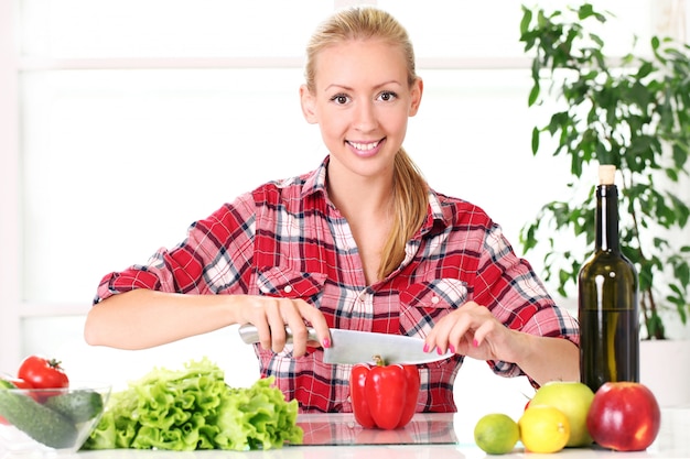 Jeune et heureuse fille préparant des aliments sains