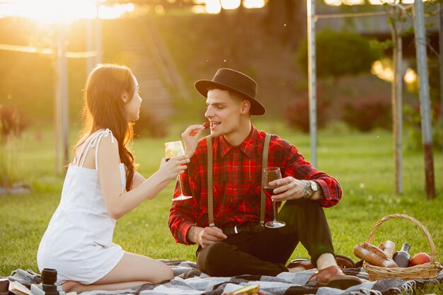 Jeune et heureux couple bénéficiant d'un pique-nique sur le parkide en journée d'été