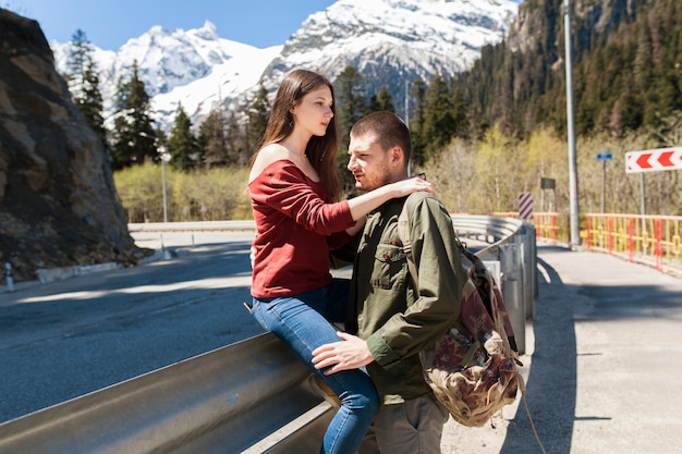 Jeune hipster beau couple amoureux, assis à la route