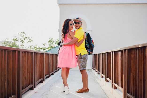 Jeune hipster beau couple amoureux, tenue d'été élégante, voyageant avec sac à dos, vacances, lunettes de soleil, coloré, souriant, heureux, positif, romantique, étreindre