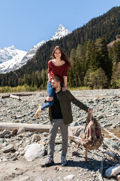 Jeune hipster beau couple randonnée à la rivière en forêt