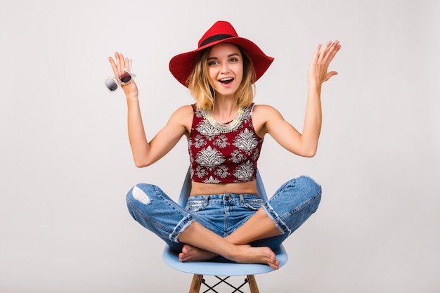 Jeune hipster belle femme assise sur une chaise isolée