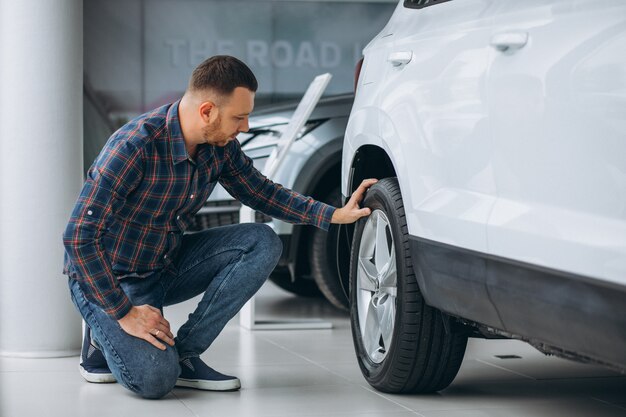 Jeune homme achète une voiture dans une salle d'exposition