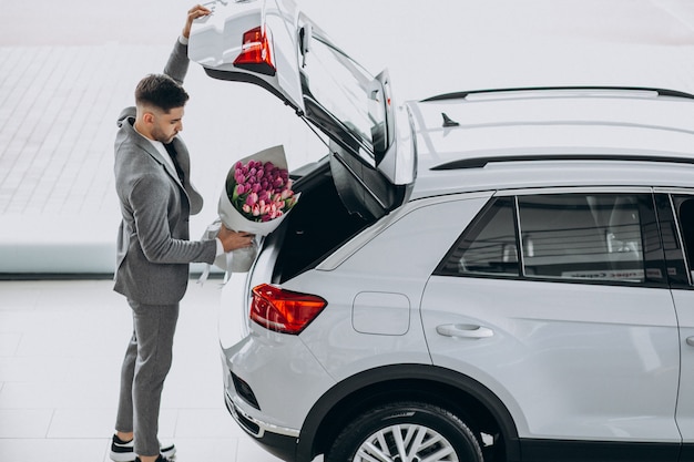 Jeune homme d'affaires beau livrer le bouquet de belles fleurs