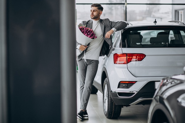 Jeune homme d'affaires beau livrer le bouquet de belles fleurs