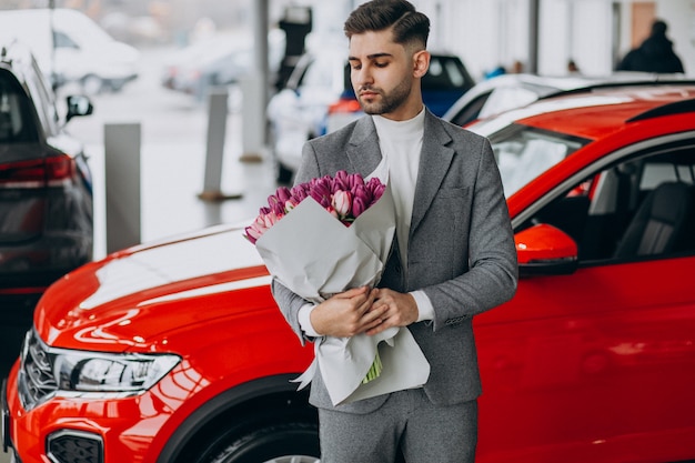 Jeune homme d'affaires beau livrer le bouquet de belles fleurs