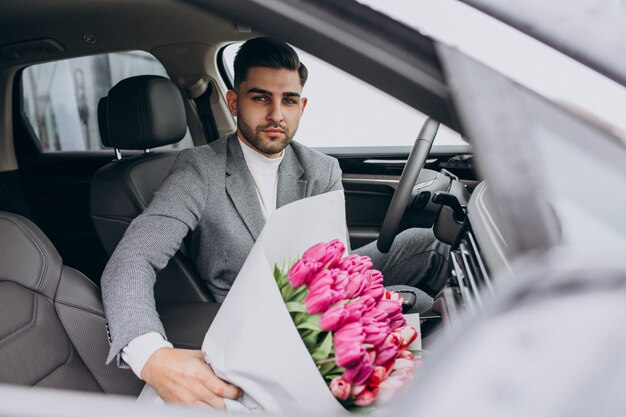 Jeune homme d'affaires beau livrer le bouquet de belles fleurs