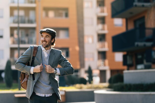 Jeune homme d'affaires heureux marchant dans la rue