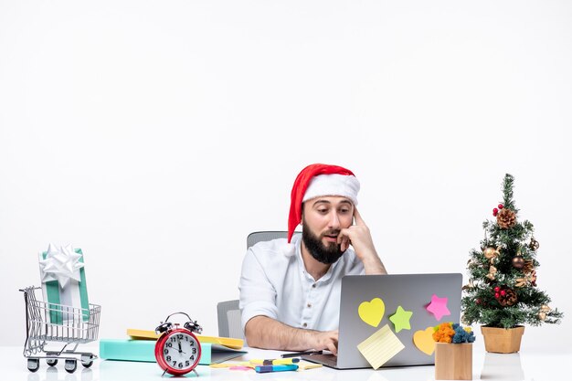 Jeune homme d'affaires joyeux occupé au bureau célébrant le nouvel an ou Noël travaillant seul sur fond blanc