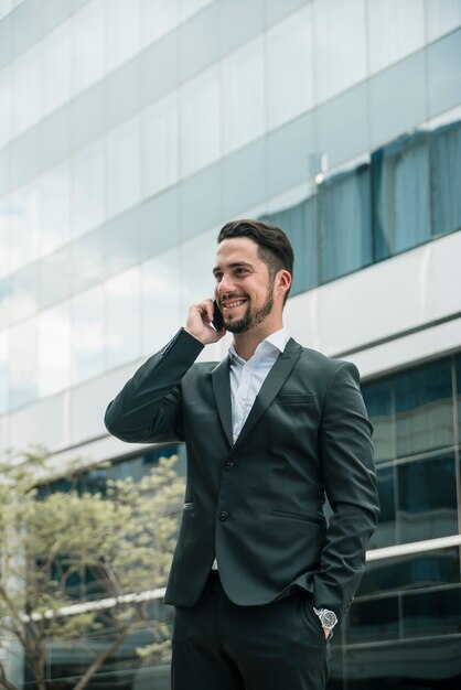 Jeune homme d&#39;affaires, parler au téléphone portable avec la main dans la poche