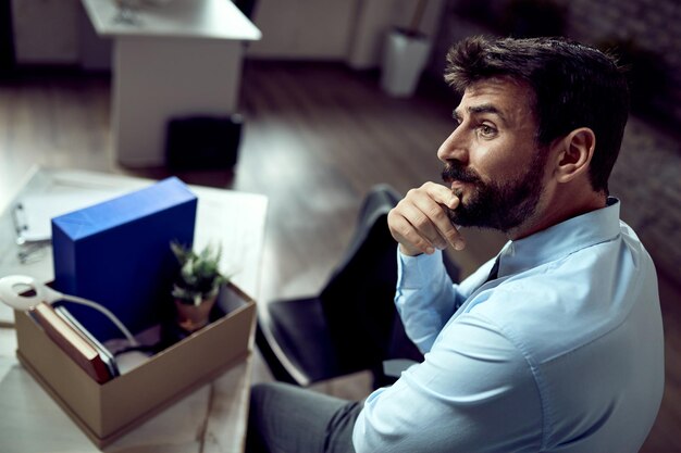 Jeune homme d'affaires pensif pensant au bureau après avoir perdu son emploi