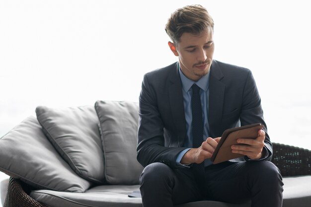 Jeune homme d&#39;affaires prospère Utiliser l&#39;ordinateur tablette