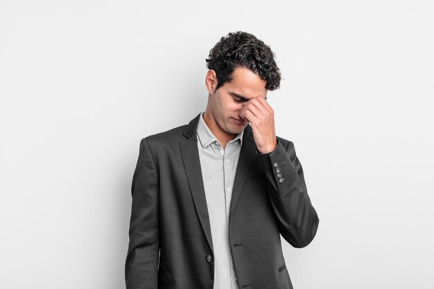Jeune homme d'affaires se sentant stressé, malheureux et frustré, touchant le front et souffrant de migraine de violents maux de tête