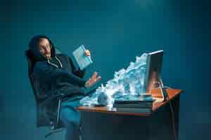 Photo gratuite jeune homme d'affaires stressé beau travaillant au bureau dans un bureau moderne criant à l'écran d'ordinateur portable et en colère contre le spam