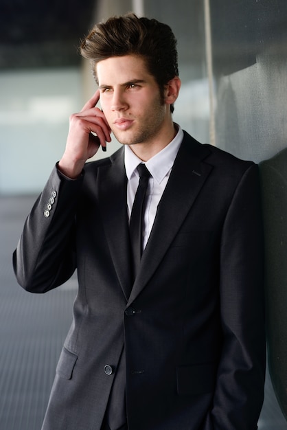 Jeune homme d&#39;affaires avec un téléphone mobile dans un immeuble de bureaux