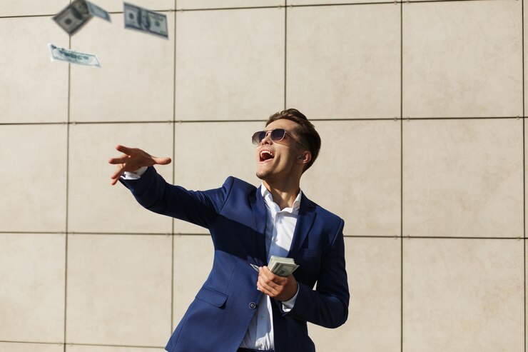 Photo gratuit jeune homme d&#39;affaires tourne autour des dollars et des danses dans la rue