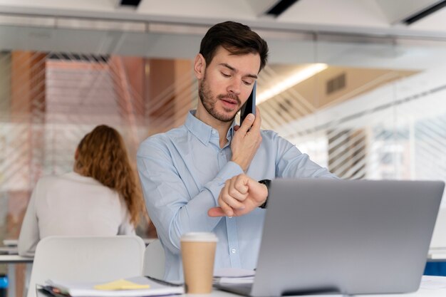 Jeune homme d'affaires travaillant à son bureau avec ordinateur portable