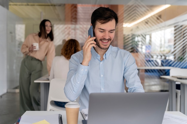 Jeune homme d'affaires travaillant à son bureau avec ordinateur portable