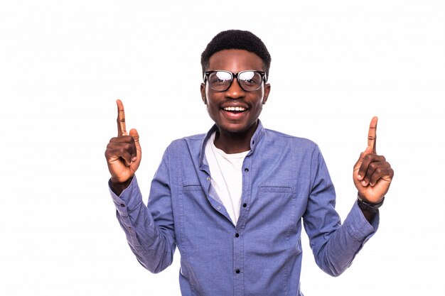 Jeune homme africain pointant vers le haut sur le mur blanc