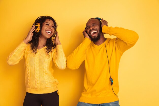 Jeune homme afro-américain émotionnel et femme sur jaune