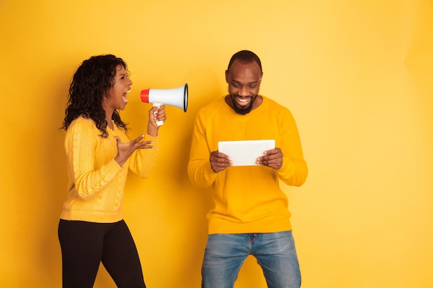 Photo gratuite jeune homme afro-américain émotionnel et femme sur jaune