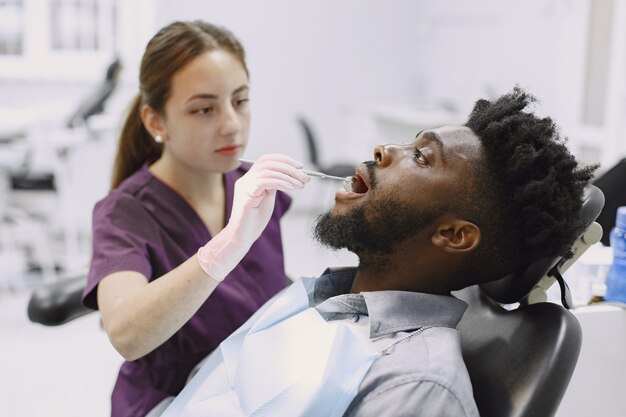 Jeune homme afro-américain. Guy visitant le cabinet du dentiste pour la prévention de la cavité buccale. Homme et médecin de famille pendant le contrôle des dents.