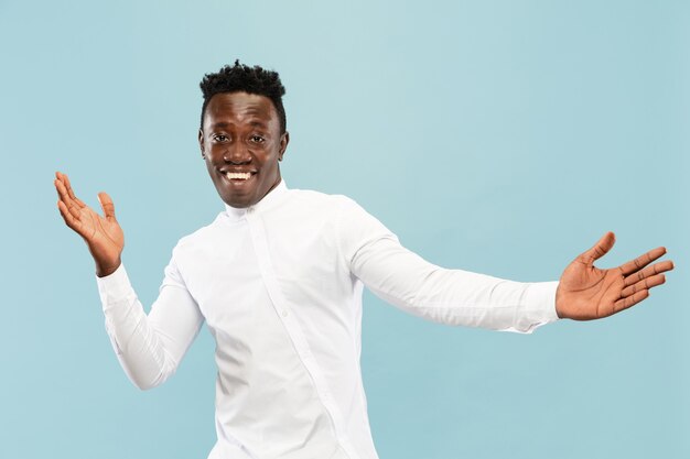 Jeune homme afro-américain isolé sur fond bleu studio