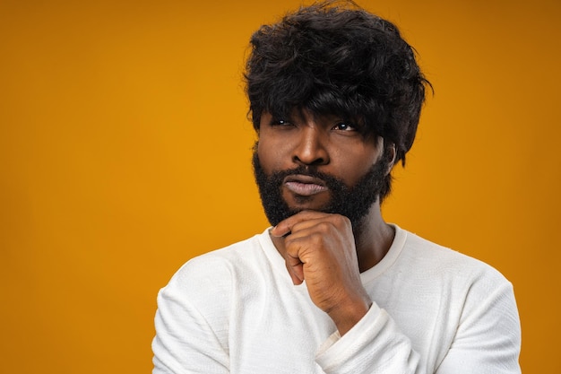 Photo gratuite jeune homme afro-américain pensant et touchant son menton