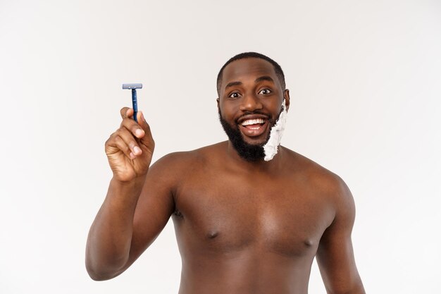 Jeune homme afro-américain se rasant dans la salle de bain hygiène de routine personnelle du matin au concept du matin