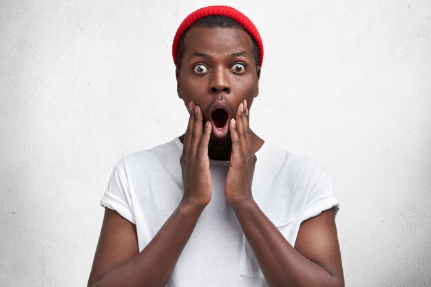 Jeune homme afro-américain en T-shirt blanc et chapeau rouge