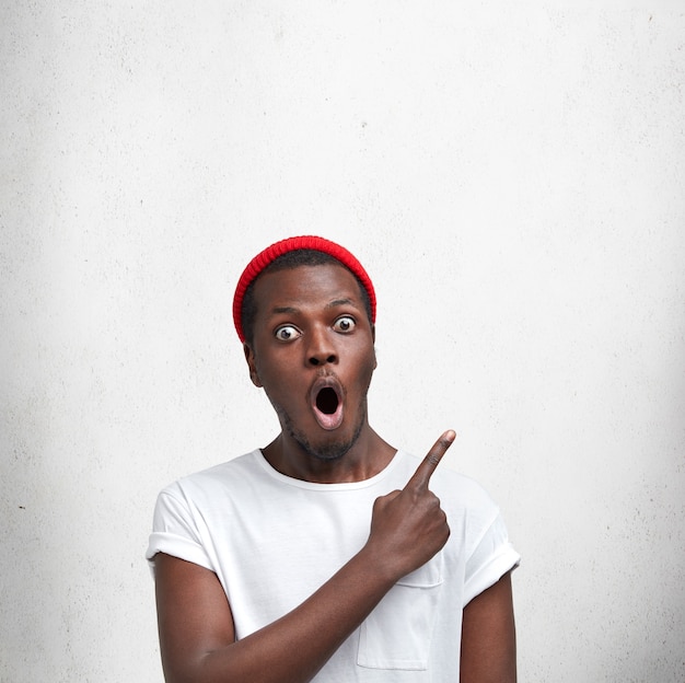 Jeune homme afro-américain en T-shirt blanc et chapeau rouge