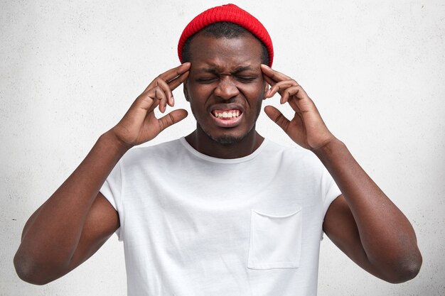 Jeune homme afro-américain en T-shirt blanc et chapeau rouge