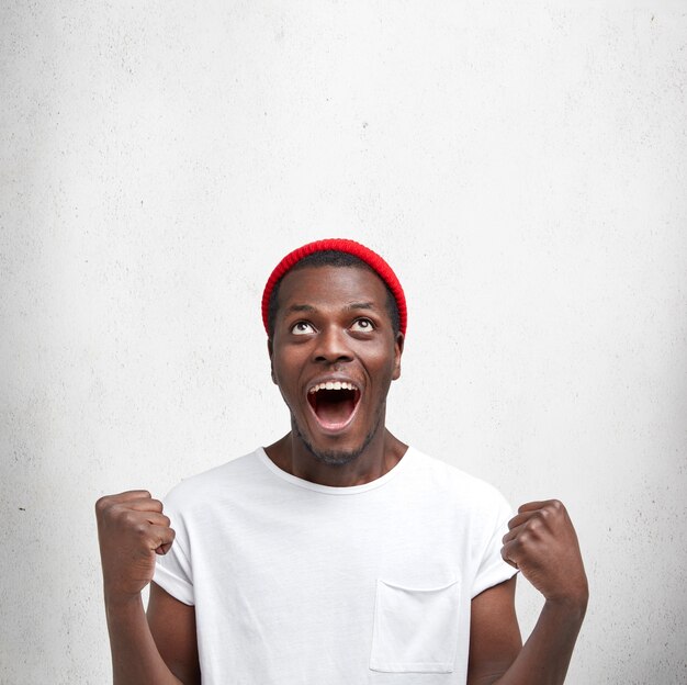 Jeune homme afro-américain en T-shirt blanc et chapeau rouge