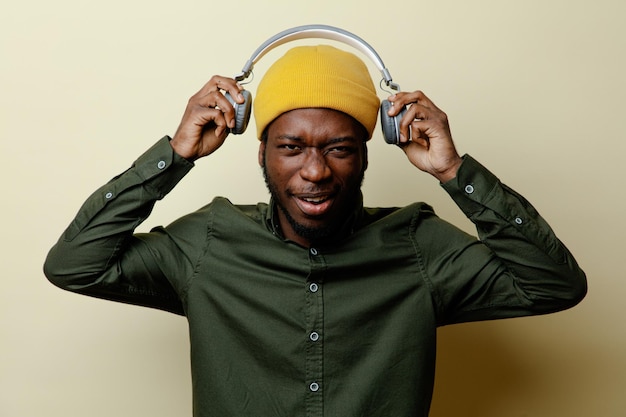 Photo gratuite jeune homme afro-américain tendu en chapeau et casque portant une chemise verte isolée sur fond blanc