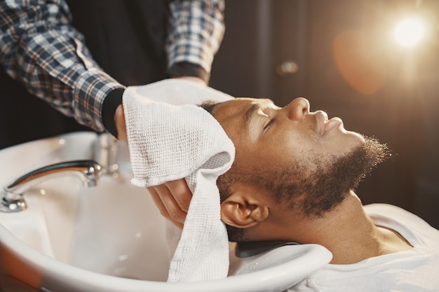 Photo gratuite jeune homme afro-américain visitant le salon de coiffure