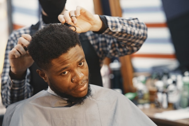 Photo gratuite jeune homme afro-américain visitant le salon de coiffure