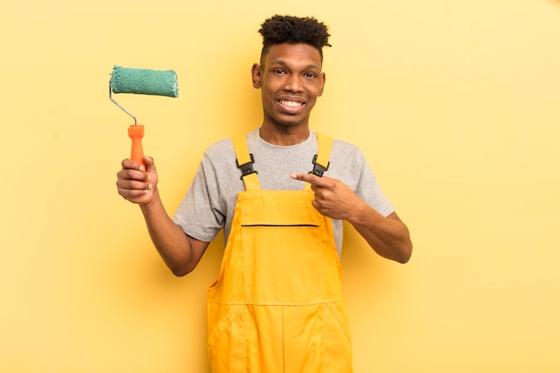 jeune homme afro contre le mur jaune