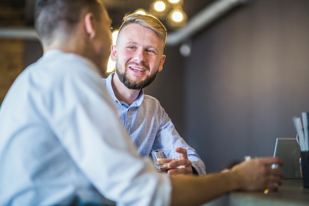 Photo gratuite jeune homme appréciant des boissons avec ses amis dans le bar