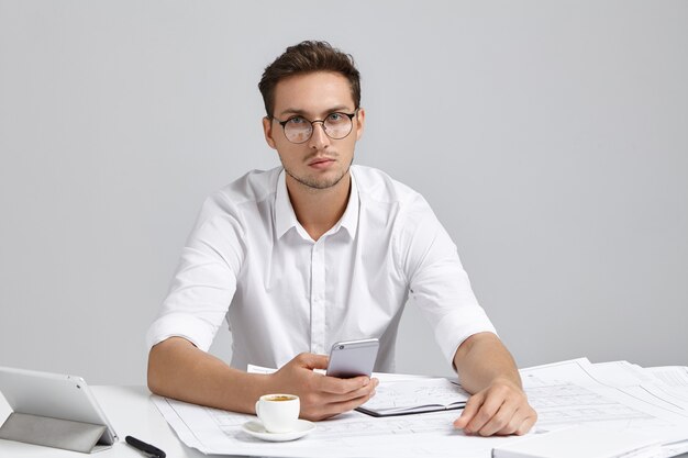 Jeune homme assis au bureau et faire de la paperasse