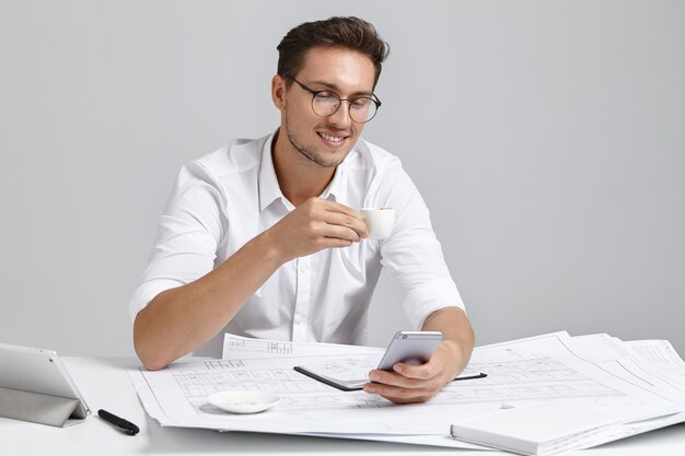 Jeune homme assis au bureau et faire de la paperasse