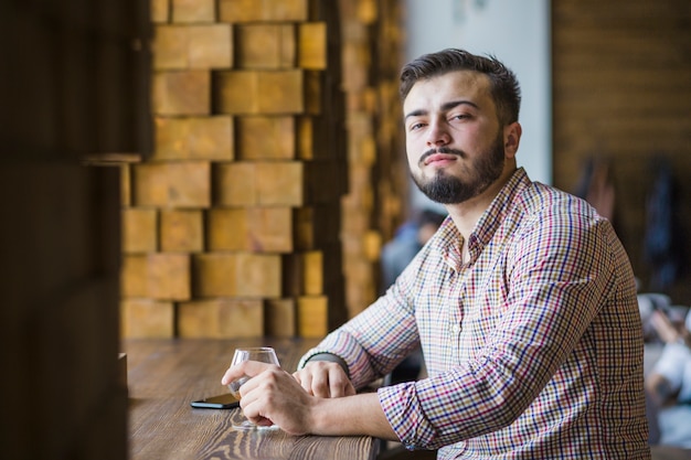 Photo gratuite jeune homme assis dans un restaurant avec un verre de boisson