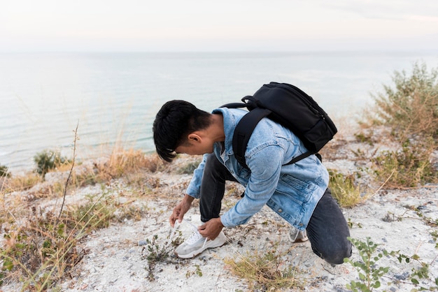 Jeune homme attachant ses lacets de chaussures