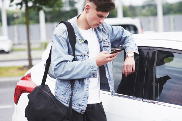 Un jeune homme attend un passager à l'aéroport.